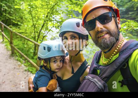 Famille heureuse portant des casques prenant un selfie lors de la visite de la gorge de vintgar à Bled, slovénie Banque D'Images