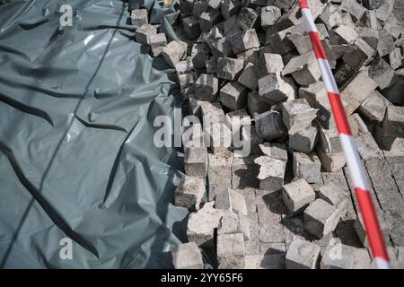 Granulé avec de nombreux pavés pavés en bloc de granit, empilés, prêts à être utilisés sur un chantier de construction, un chantier de rénovation de routes et de trottoirs Banque D'Images