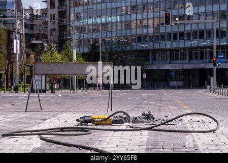 Une pierre a été enlevée d'un passage pour piétons avec une perceuse à percussion rotative électrique. Gros plan. Zone de construction ou travaux routiers sur la rue de la ville. Banque D'Images