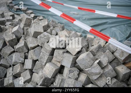 Granulé avec de nombreux pavés pavés en bloc de granit, empilés, prêts à être utilisés sur un chantier de construction, un chantier de rénovation de routes et de trottoirs Banque D'Images