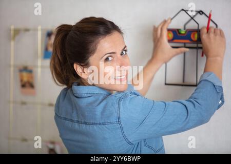 décorateur accrochant l'image sur un mur Banque D'Images