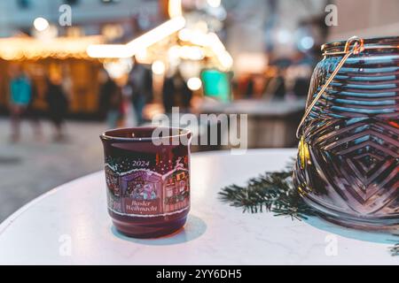 Bâle, Suisse - 5 décembre 2024 : marché de Noël traditionnel mug à vin chaud le soir sur la Barfusserplatz avec des lumières festives Banque D'Images