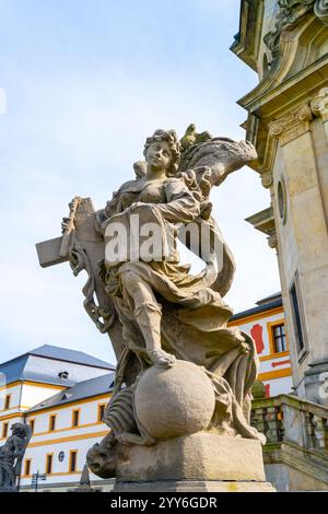 Une vue détaillée d'une statue baroque, présentant un design complexe, située dans le complexe hospitalier Kuks en Tchéquie. La statue ajoute une valeur historique à la belle architecture qui l'entoure. Banque D'Images