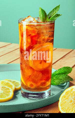 Grand verre rafraîchissant de thé glacé d'été glacé avec tranches de citron jaune et de vert feuille de menthe Banque D'Images