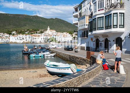 Hommes et femmes sur la promenade animée du port de Cadaqués sous le soleil du matin, Catalogne, Espagne Banque D'Images