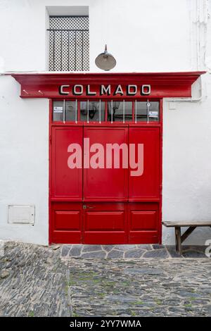 Porte en bois rouge fermée d'un magasin général dans le vieux centre-ville de Cadaqués, Catalogne, Espagne Banque D'Images