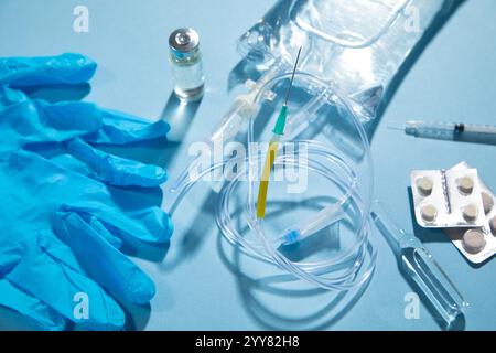 Poche de perfusion, seringue, ampoules médicales dans le fond bleu. Chambre goutte-à-goutte IV Banque D'Images