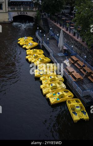 Prague, République tchèque. 3 octobre 2024 - pédalos jaunes alignés le long de la rivière Vltava Banque D'Images