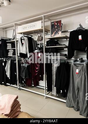 Kiev, Ukraine - 18 décembre 2024 : une exposition de vêtements bien organisée dans un magasin de détail contemporain présentant des tenues et des accessoires modernes élégants. Banque D'Images