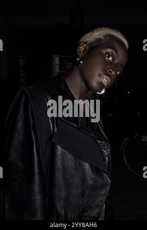 Jeune femme noire blonde dehors. Elle porte un manteau noir Banque D'Images