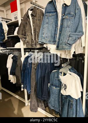 Kiev, Ukraine - 18 décembre 2024 : vestes, chemises et hauts en denim exposés sur des supports dans un cadre de magasin de détail moderne. Idéal pour mettre en valeur la mode t Banque D'Images