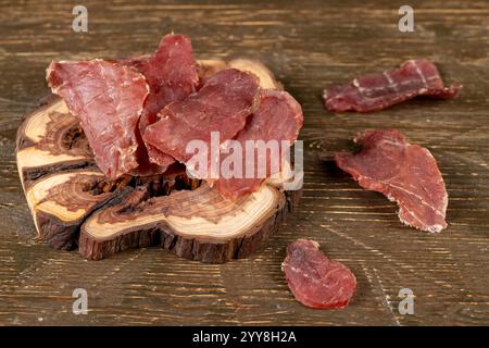 morceaux de porc tranchés, viande séchée séchée à partir de filet de viande avec épices et sel sur ardoise noire Banque D'Images