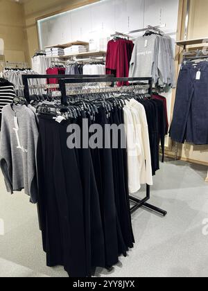 Kiev, Ukraine - 18 décembre 2024 : un magasin présentant une collection de vêtements d'hiver avec des pulls et des pantalons de premier plan. Vêtements disposés sur des étagères Banque D'Images