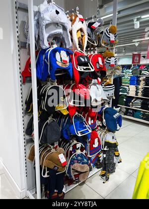 Kiev, Ukraine - 18 décembre 2024 : une exposition vibrante mettant en vedette différents styles de chapeaux d'hiver pour enfants, mettant en vedette des dessins de personnages populaires et brick Banque D'Images