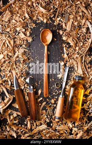 Cuillère en bois artisanale confortable avec tas de limailles en bois avec des outils de menuiserie manuelle. Concept de fabrication artisanale Banque D'Images