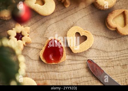 Remplissage de biscuits de Noël Linzer en forme de coeur avec marmelade de fraises rouges, vue de dessus Banque D'Images