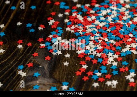 bonbons sucrés en forme d'étoile, bonbons au sucre rouge blanc et bleu pour la décoration sur fond noir Banque D'Images