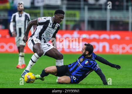 (R-G) Hakan Calhanoglu du FC Internazionale concourt pour le ballon avec James Abankwah du Udinese Calcio lors du match de football Coppa Italia 2024/25 entre le FC Internazionale et le Udinese Calcio au stade San Siro Banque D'Images