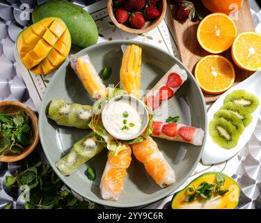 '🍓🥭 Un éclat de fraîcheur tropicale dans chaque bouchée ! Ces rouleaux de printemps aux fruits sont emballés avec de la mangue juteuse, du kiwi, de la fraise et de l'orange, enveloppés dans une charcuterie Banque D'Images