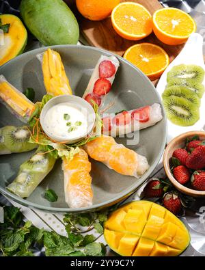 '🍓🥭 Un éclat de fraîcheur tropicale dans chaque bouchée ! Ces rouleaux de printemps aux fruits sont emballés avec de la mangue juteuse, du kiwi, de la fraise et de l'orange, enveloppés dans une charcuterie Banque D'Images