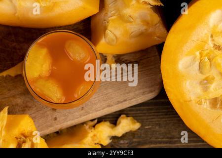 citrouille avec des graines et jus de citrouille coupé en morceaux et jus de citrouille, partie de citrouille avec pulpe douce et sucrée et un verre de jus de pulpe Banque D'Images