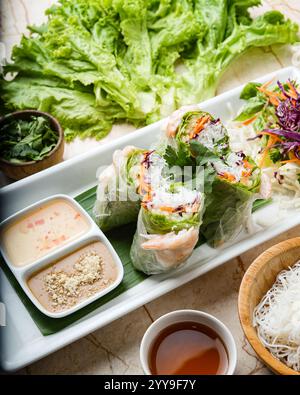 Rouleaux de printemps vietnamiens frais emballés avec des nouilles vermicelles, des légumes croustillants et des crevettes, servis avec une sauce savoureux à la cacahuète, parfait pour un Li Banque D'Images