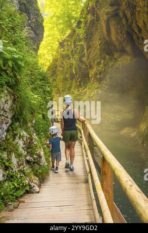 Mère et fils portant des casques profitent d'une promenade dans la magnifique gorge de vintgar près de Bled, slovénie, par une belle journée d'été Banque D'Images