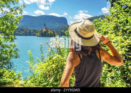 Touriste appréciant les vacances d'été au lac saigné, lac glaciaire dans les alpes juliennes avec église de l'Assomption de marie sur une petite île Banque D'Images