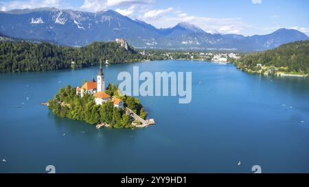 Vue aérienne du lac Bled avec l'église de l'Assomption de marie sur une petite île, avec des kayakistes profitant de l'été dans les alpes juliennes Banque D'Images