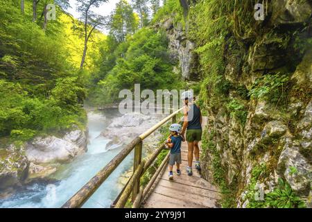 Mère et enfant marchant sur un chemin en bois explorant la gorge de vintgar près de Bled, profitant de vacances d'été dans la belle nature de la slovénie Banque D'Images