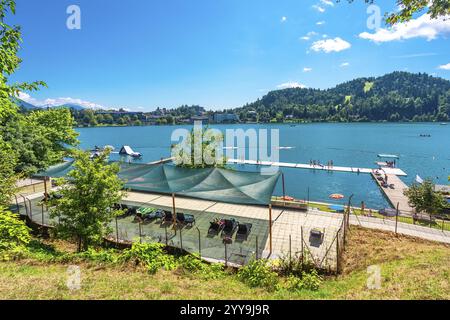 Touristes appréciant les vacances d'été, la baignade et les bains de soleil sur la rive du lac saigné, un beau lac glaciaire niché dans les alpes juliennes de slovénie Banque D'Images