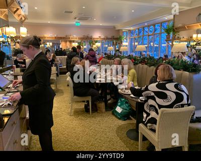Magasin de thé Betty à Ilkley Yorkshire Angleterre nourriture manger l'après-midi tasse de thé soucoupe crème scones petits pains gâteaux serveuse à l'intérieur du stand magasin personne Banque D'Images