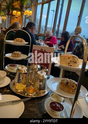 Magasin de thé Betty à Ilkley Yorkshire Angleterre nourriture manger l'après-midi tasse de thé soucoupe crème scones petits pains gâteaux serveuse à l'intérieur du stand magasin personne Banque D'Images