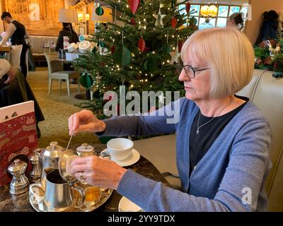 Magasin de thé Betty à Ilkley Yorkshire Angleterre nourriture manger l'après-midi tasse de thé soucoupe crème scones petits pains gâteaux serveuse à l'intérieur du stand magasin personne Banque D'Images