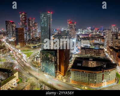 Centre-ville de Manchester la nuit avec des rues illuminées, des bâtiments modernes et l’horizon dynamique de Greater Manchester. Banque D'Images