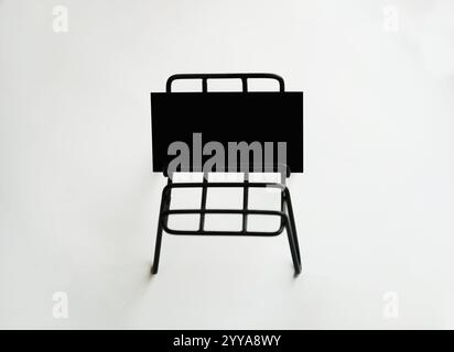 Maquette de cartes de visite vierges noires empilées sur une petite chaise Banque D'Images