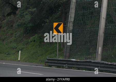 La flèche à gauche d'un virage sur la route indique le mouvement autorisé aux conducteurs circulant dans cette voie Banque D'Images