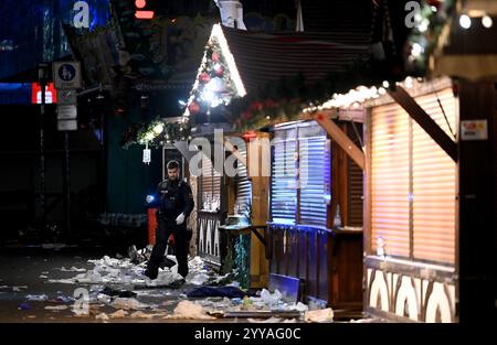 Magdebourg, Allemagne. 20 décembre 2024. Un policier examine la scène du crime au marché de Noël. Crédit : Heiko Rebsch/dpa/Alamy Live News Banque D'Images