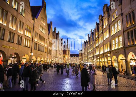 Münster, NRW, Allemagne, 20 décembre 2024. Le célèbre boulevard Prinzipalmarkt est fermé à la circulation et très fréquenté par les visiteurs. Münster (Muenster) et ses cinq marchés de Noël sont animés par des foules de visiteurs festifs de toute la NRW, ainsi que des pays-Bas et d'ailleurs ce soir. Des milliers de personnes affluent vers les marchés traditionnels du pittoresque centre-ville historique. Une sécurité renforcée est visible, les voies d'accès sont limitées, les espaces entre les rues et les marchés ont été bloqués avec des sacs de sable en acier ou en béton et d'autres mesures. Ce soir, une attaque a été menée à Magdebourg Christmas Banque D'Images