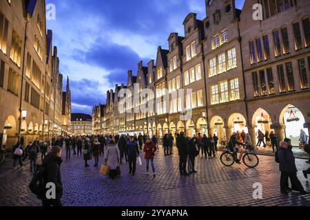 Münster, NRW, Allemagne, 20 décembre 2024. Le célèbre boulevard Prinzipalmarkt est fermé à la circulation et très fréquenté par les visiteurs. Münster (Muenster) et ses cinq marchés de Noël sont animés par des foules de visiteurs festifs de toute la NRW, ainsi que des pays-Bas et d'ailleurs ce soir. Des milliers de personnes affluent vers les marchés traditionnels du pittoresque centre-ville historique. Une sécurité renforcée est visible, les voies d'accès sont limitées, les espaces entre les rues et les marchés ont été bloqués avec des sacs de sable en acier ou en béton et d'autres mesures. Ce soir, une attaque a été menée à Magdebourg Christmas Banque D'Images