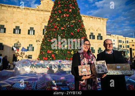 La Valette, Malte. 20 décembre 2024. Les personnes qui détiennent des cadeaux de Noël sont vues lors d'un événement caritatif de don de cadeaux de Noël à des enfants dans le besoin à Castille Square à la Valette, Malte, le 20 décembre 2024. Crédit : Jonathan Borg/Xinhua/Alamy Live News Banque D'Images