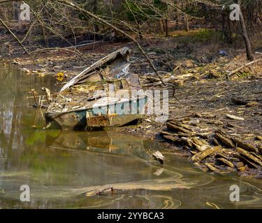 Les restes d'un vieux bateau de pêche en bois abandonné et naufragé sur une rive d'un lac dans le parc d'État de Harrison Bay, Tennessee. Banque D'Images