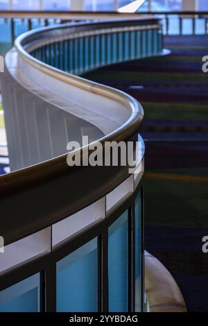Balustrade en verre incurvé de teinte bleue. Le garde-corps est incurvé et possède une surface brillante et réfléchissante Banque D'Images