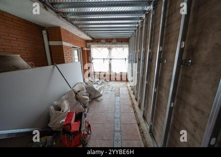 Pièce en rénovation avec installation de panneaux muraux préfabriqués et démolition du plancher. Banque D'Images