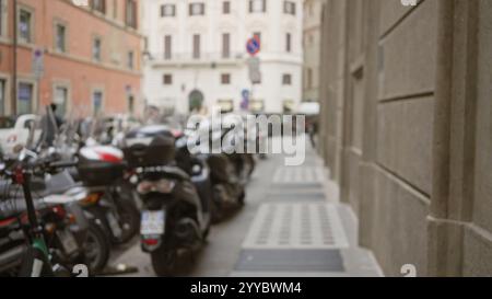 Scène de rue bokeh à rome avec fond flou montrant des scooters alignés le long d'une ruelle de la vieille ville. Banque D'Images