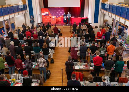 21 décembre 2024, Thuringe, Sömmerda : les délégués se tiennent ensemble pendant une minute de silence pour les victimes de l'attaque du marché de Noël de Magdebourg lors de la conférence du parti Die Linke Thüringen au Volkshaus. Les délégués veulent dresser la liste des États pour les élections fédérales de 2025. Photo : Michael Reichel/dpa crédit : dpa Picture alliance/Alamy Live News Banque D'Images