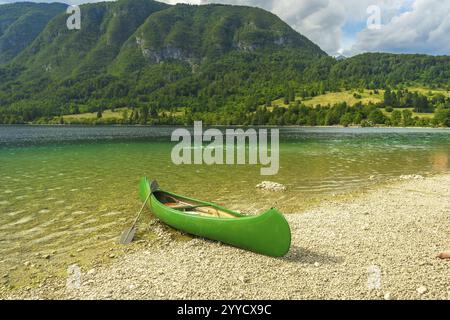 Green Canoe se trouve sur la rive galbée du lac Bohinj, invitant les visiteurs à explorer le magnifique paysage slovène Banque D'Images