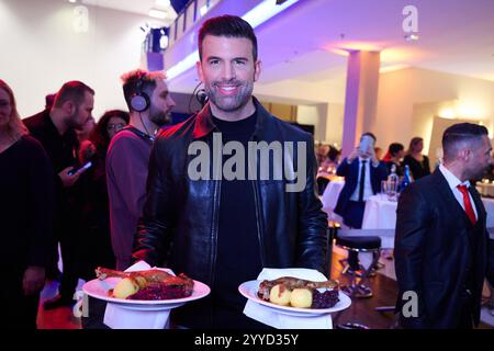 Berlin, Allemagne. 21 décembre 2024. Jay Khan sert des oies rôties aux clients nécessiteux et sans-abri. La 30ème fête de Noël de Frank Zander pour les sans-abri a lieu aujourd'hui à l'Hôtel Estrel. Crédit : Annette Riedl/dpa/Alamy Live News Banque D'Images