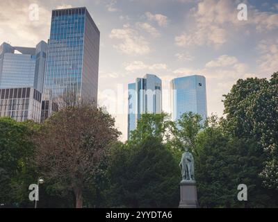 Francfort, Allemagne - 15 mai 2023 : statue de Schiller denkmal dans le parc de Taunusanlage sur fond de gratte-ciel modernes dans le quartier des affaires en soirée Li Banque D'Images