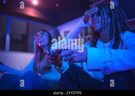 Couple compétitif jouant à un jeu vidéo dans leur salon, s'amusant à jouer à des jeux vidéo ensemble à la maison. Concept Gaming streaming Banque D'Images
